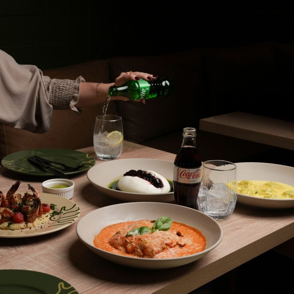 فيتالي V itlay طاولة عليها طبق باستا بالصوص الاحمر وسلطة البوراتا وكولا