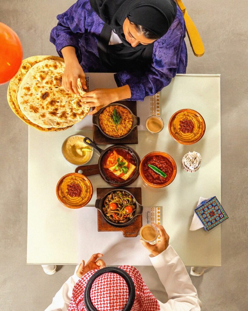 تميسة: طاولة عليها حمسة حلوم وكبدة وحمسة طماطم وفول وشكشوكة وحمص وشاي كرك سفرة تميسة اللذيذة