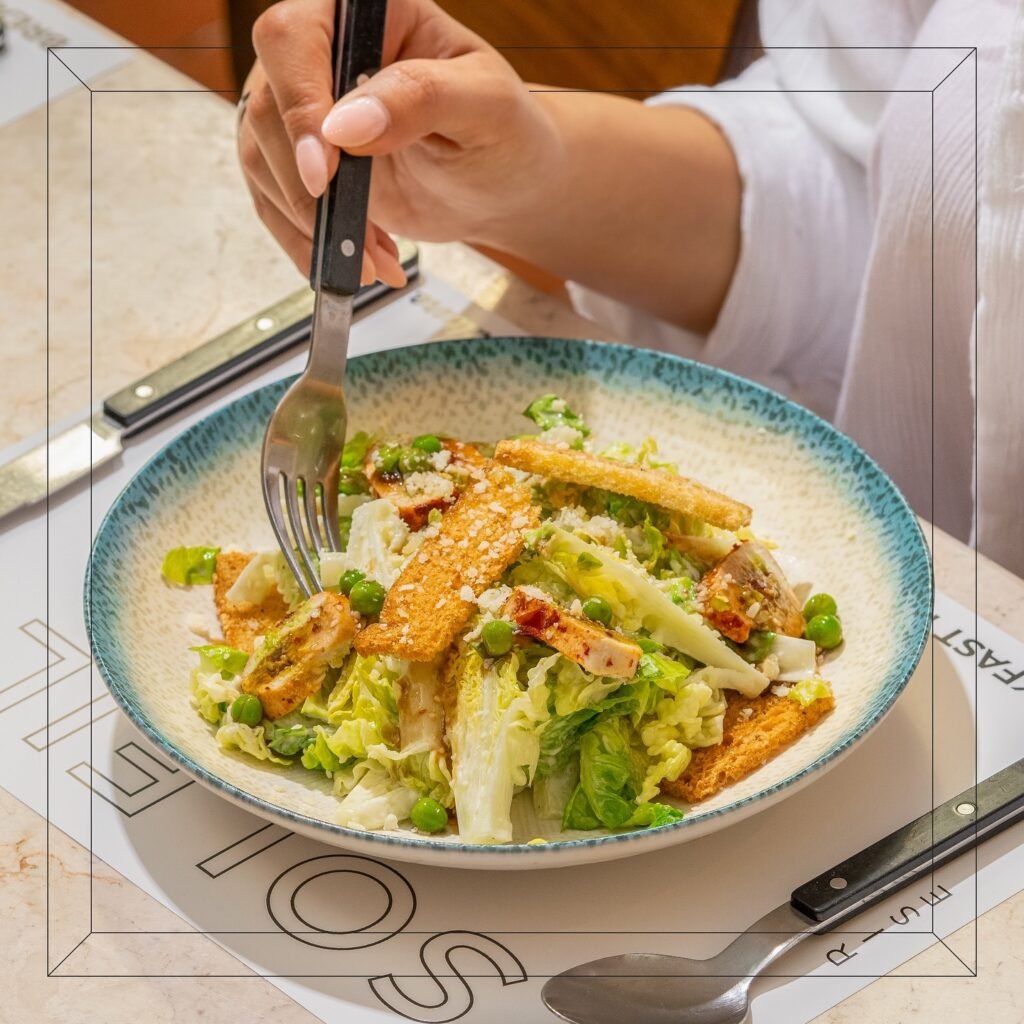 سوليه Soleil: سلطة سيزر طازجة مع قطع دجاج مشوي، وخس روماني، وخبز مقرمش، وجبن بارميزان، وصوص سيزر كريمي بتقديم أنيق.