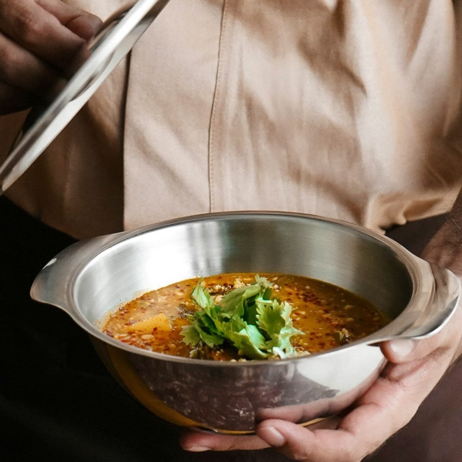 ذا تاي تيبل The Thai Table: وعاء من الشوربة التايلندية الساخنة، يزينه الكزبرة والتوابل، يُقدَّم بتقديم بسيط يعكس دفء النكهات الآسيوية وأصالته